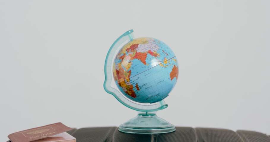 Globo terrestre ao lado de passaporte representando tributacao ITCMD sobre bens e heranca no exterior