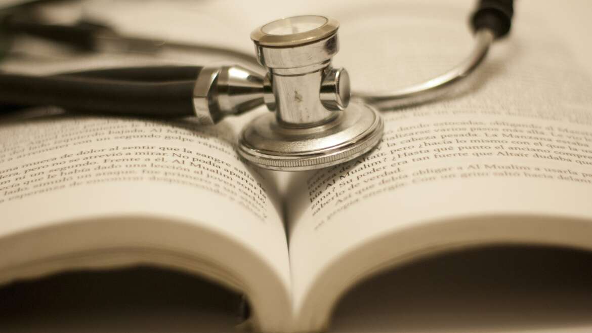 Estetoscopio sobre livro representando o direito do paciente ao tratamento indicado pelo medico
