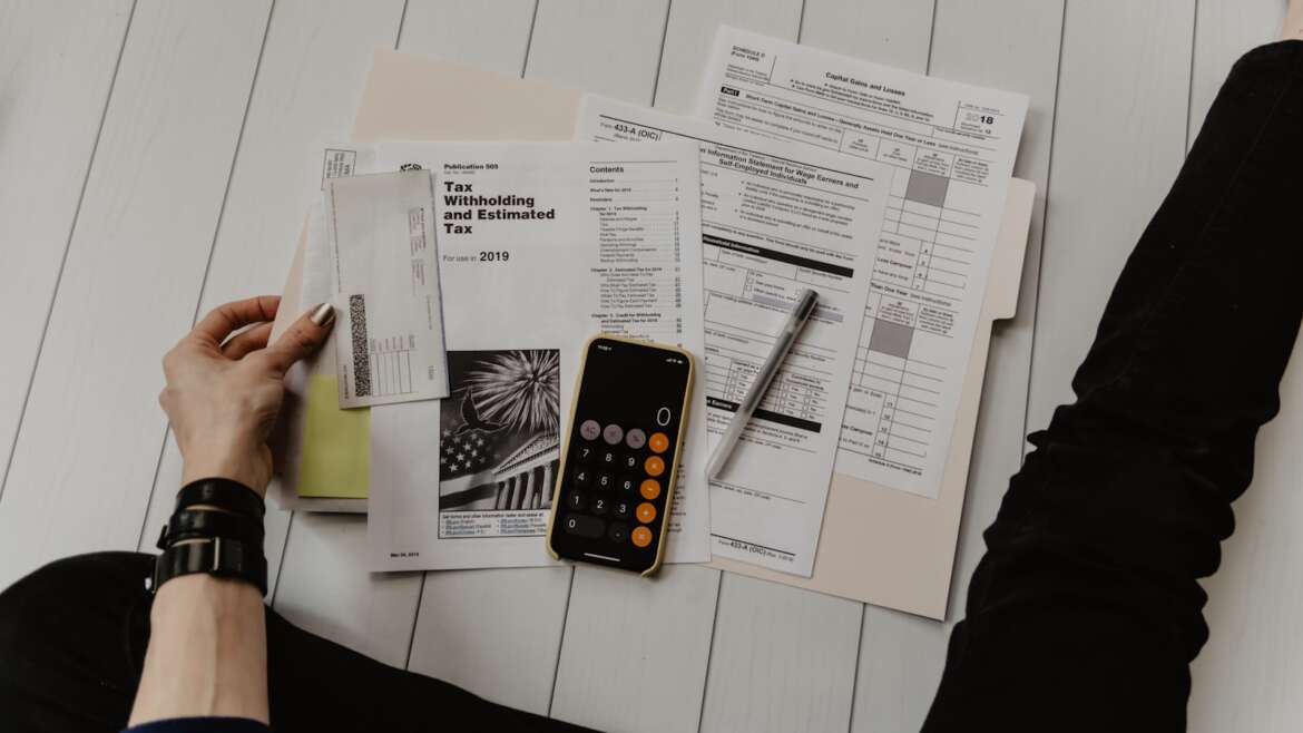 Documentos societários, balanço empresarial e calculadora sobre mesa, simbolizando quotas sociais e holdings familiares no inventário