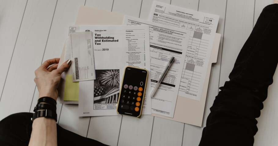 Documentos societários, balanço empresarial e calculadora sobre mesa, simbolizando quotas sociais e holdings familiares no inventário