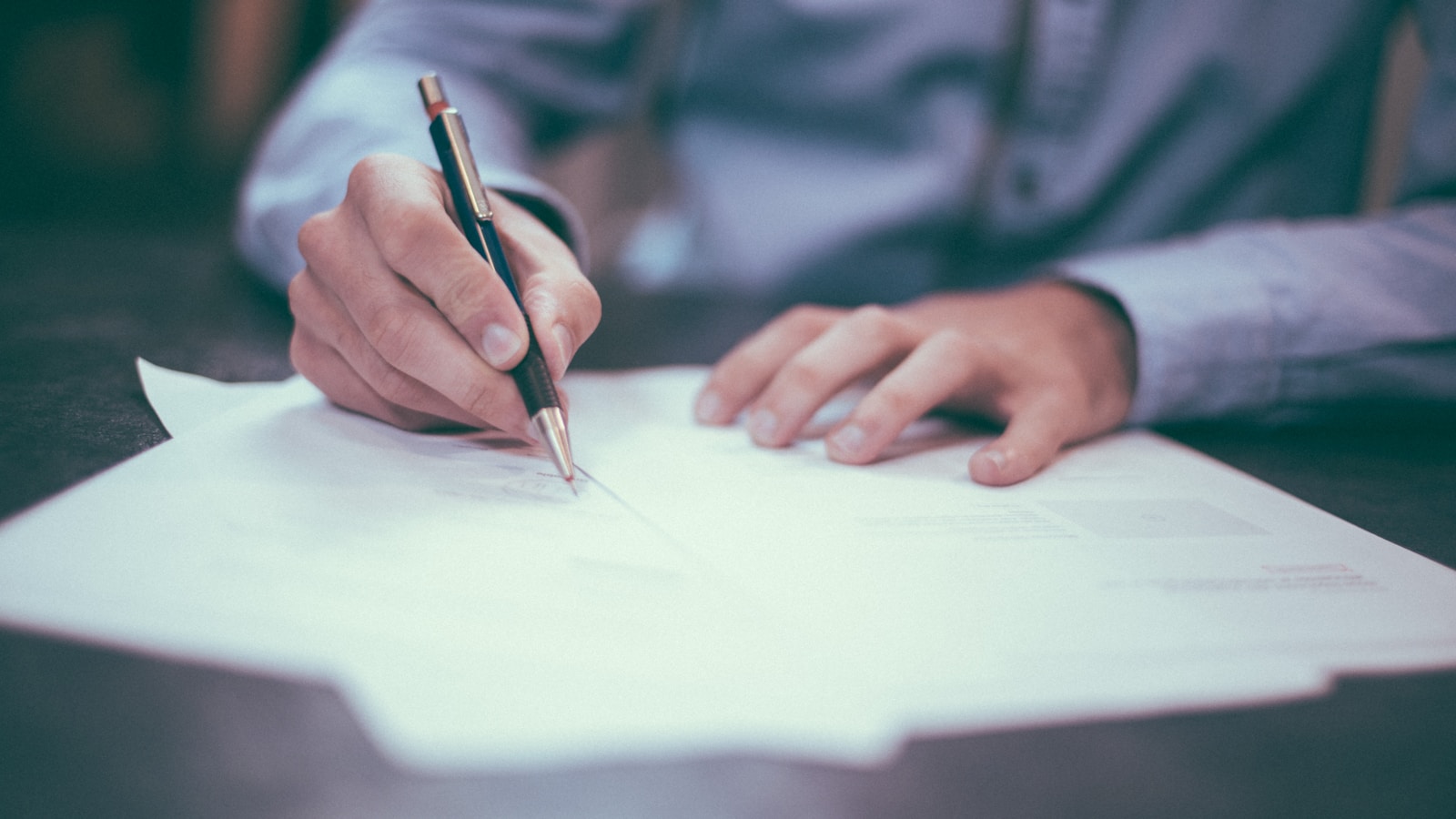 Contrato imobiliário e chaves sobre mesa, simbolizando responsabilidade civil e criminal do corretor de imóveis e da imobiliária