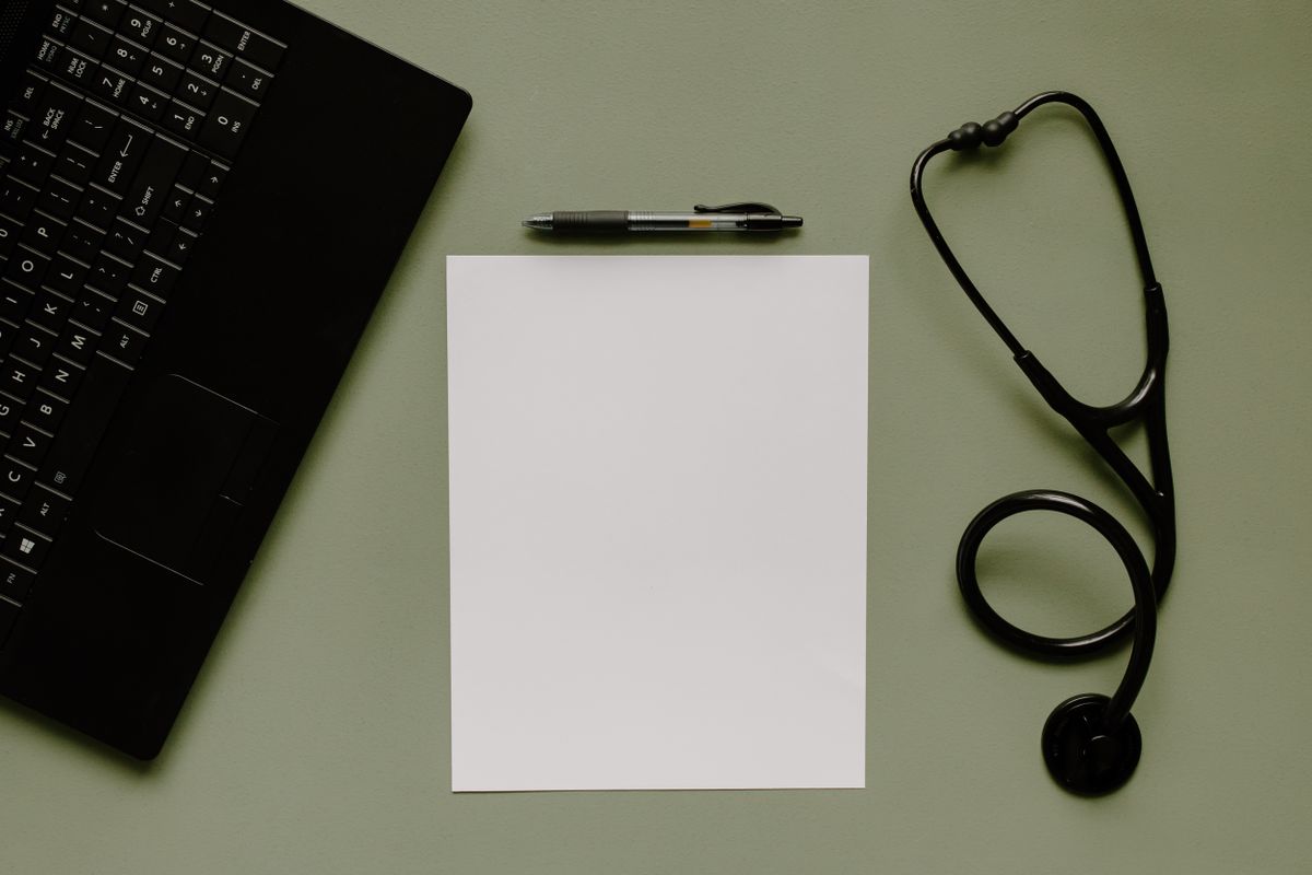 Mesa médica com prontuário, caneta e estetoscópio