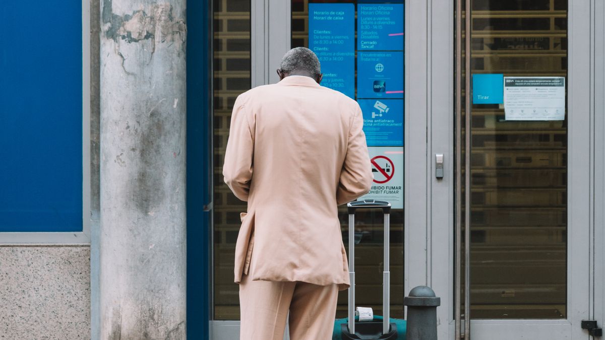Homem em um terminal de autoatendimento bancário, representando saques na conta após o falecimento do titular.