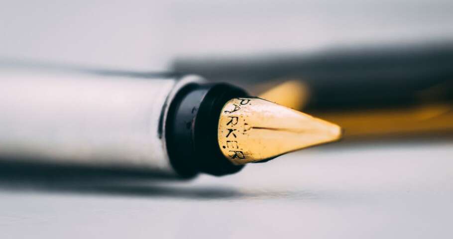 Caneta-tinteiro em detalhe sobre a mesa, representando a alteração e a revogação de um testamento.
